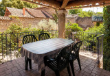 Terrasse ombragée avec table, chaises et barbecue