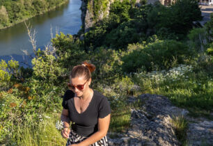 une jeune fille se promène sur les hauteurs d'Aiguèze, on aperçoit le village médiéval en arrière plan