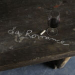 Table gravée à la craie avec le nom du domaine et un verre de vin rouge
