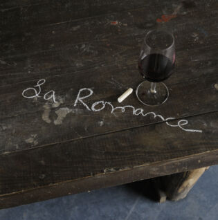 Table gravée à la craie avec le nom du domaine et un verre de vin rouge