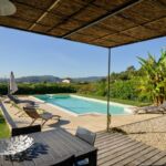 Terrasse ombragée avec vue sur la piscine et le vignoble
