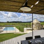 Vue de la terrasse sur la piscine et le jardin