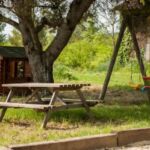 Jardin avec aire de jeux, cabane et terrain de pétanque