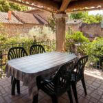 Terrasse ombragée avec table, chaises et barbecue