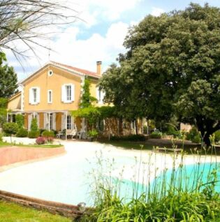 Vue de la maison avec piscine et jardin