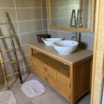 Salle d'eau du chalet avec lavabo, douche et rangement
