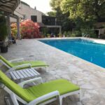 Vue sur la piscine avec terrasse et transats
