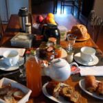 Table du petit-déjeuner avec viennoiseries, jus de fruit, confitures...