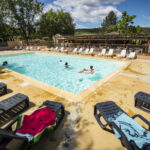 Grande piscine du camping avec transats