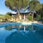 Vue sur la bâtisse, le jardin et la piscine
