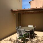 Petite terrasse couverte avec table et chaises