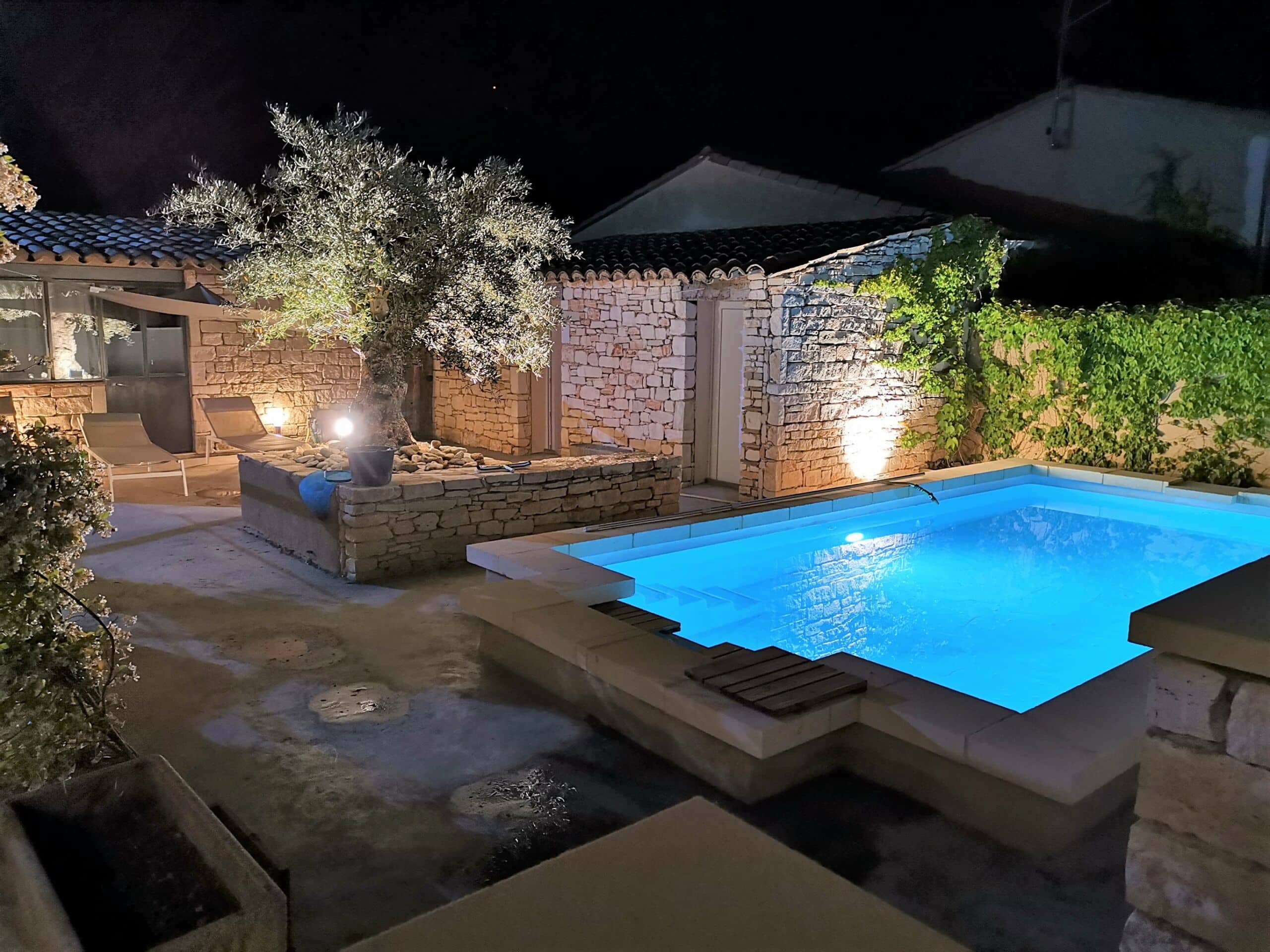 Vue sur la piscine et la terrasse en soirée