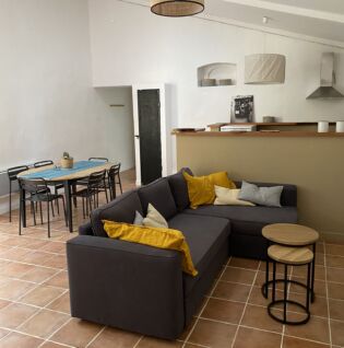 Pièce de vie avec salon, coin repas et cuisine ouverte